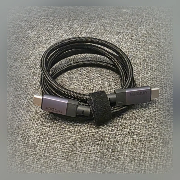 Flätad UGREEN-kabel hoprullad, med märkningen 40Gbps på kontakten.